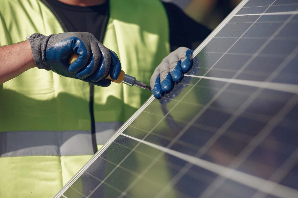 Mitarbeiter schraubt am Solar Panel
